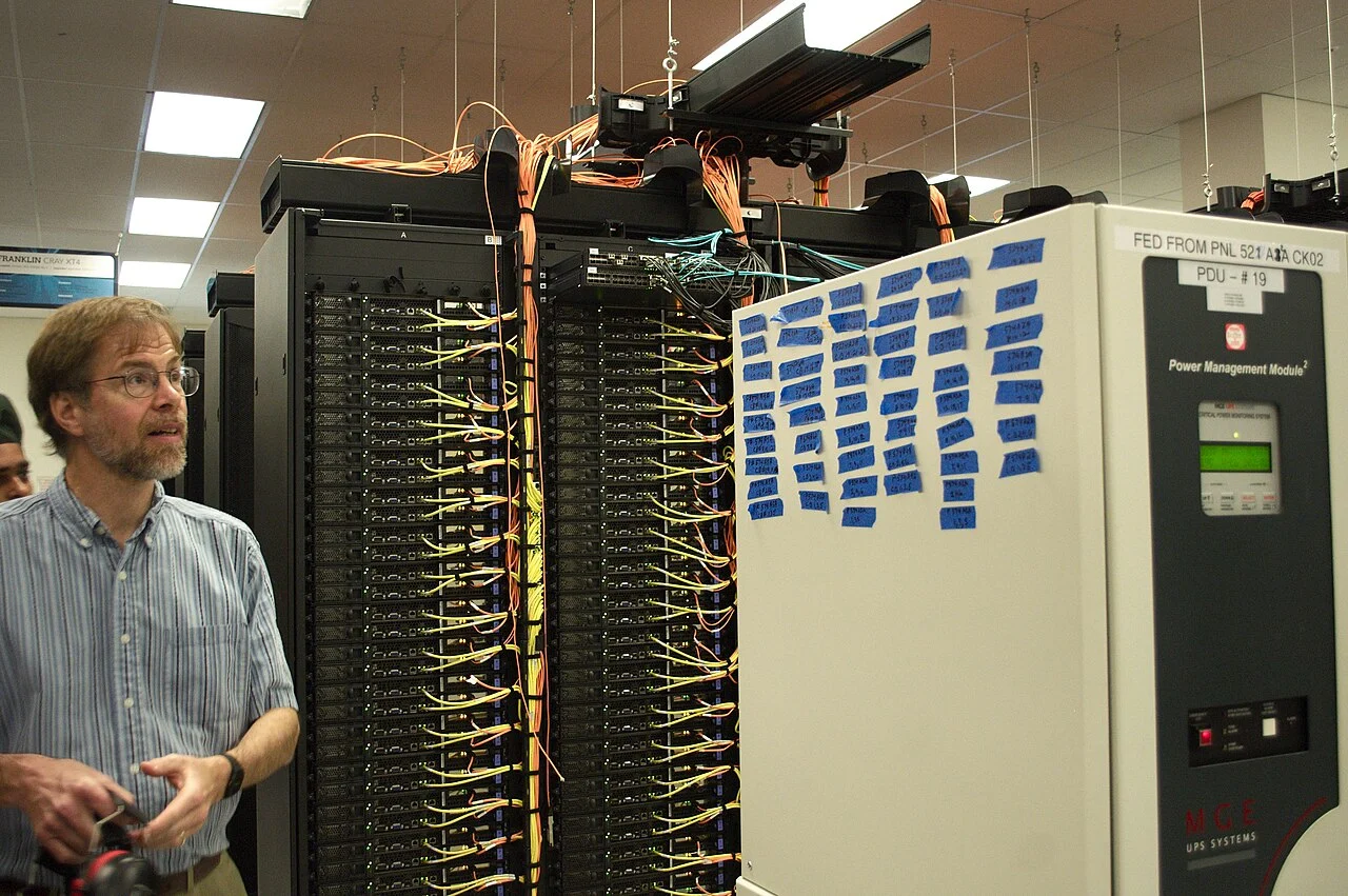 Large data center with rows of servers and visible electrical power connections