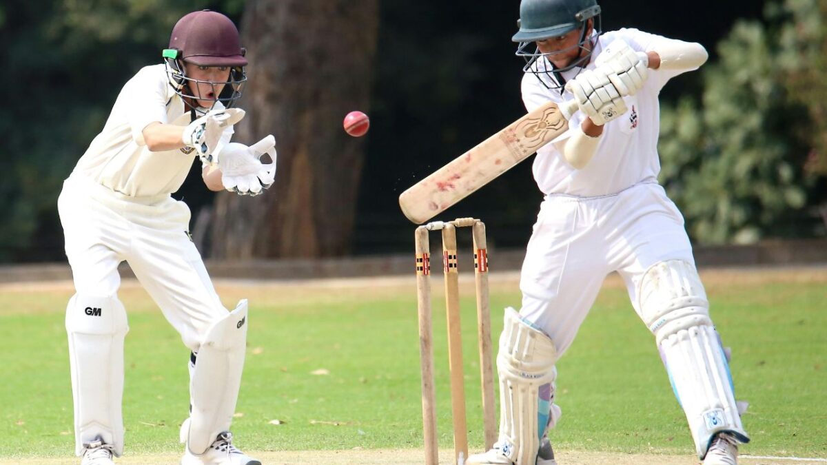 Wicketkeeper catching the ball behind the stumps in how is cricket played