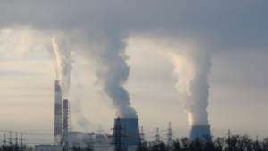 Factory emitting smoke with digital overlay representing eu carbon tax rules