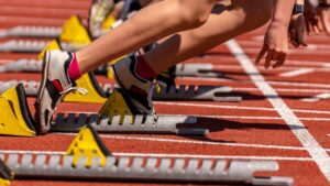 A long jumper landing in a sand pit explaining what are the events in track and field